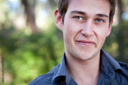 close-up portrait of a casual handsome man smiling while outdoor