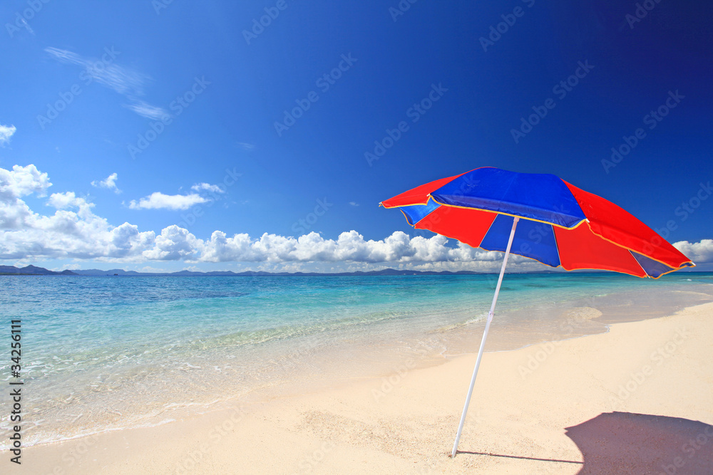 真っ白な砂浜に立つビーチパラソル