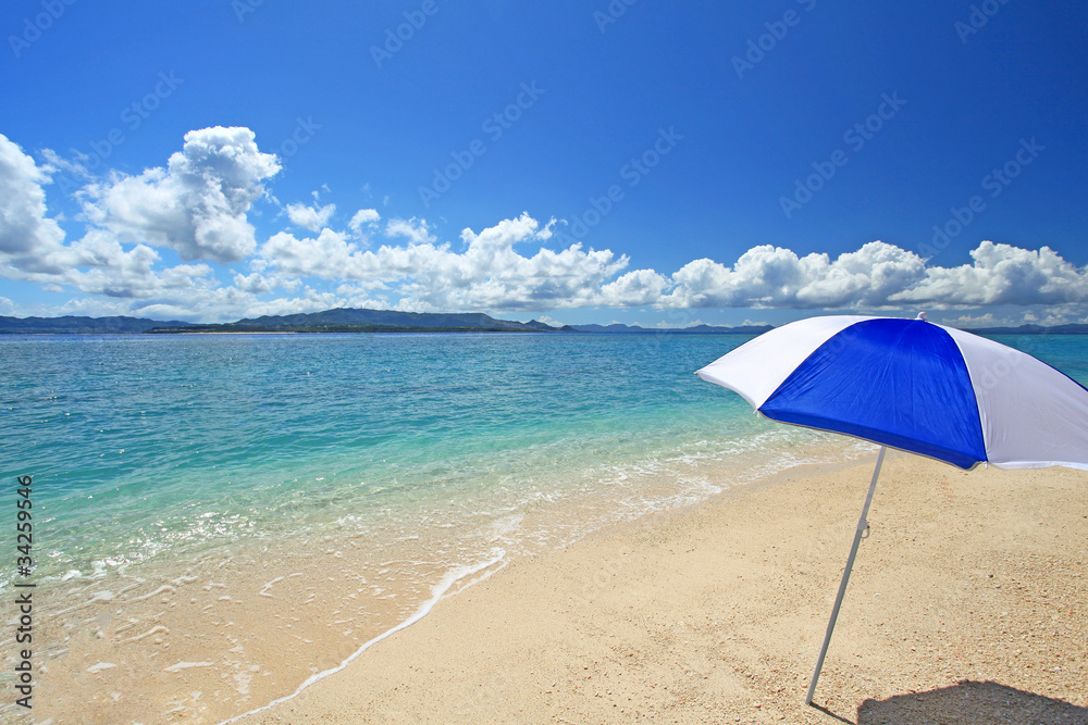 水納島の白い砂浜に立つビーチパラソル
