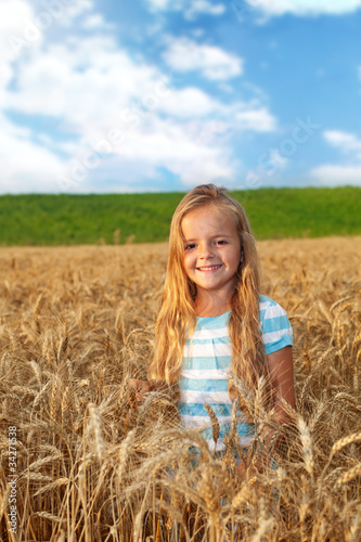 Fototapeta Naklejka Na Ścianę i Meble -  Golden hair girl on wheat field in late afternoon lights