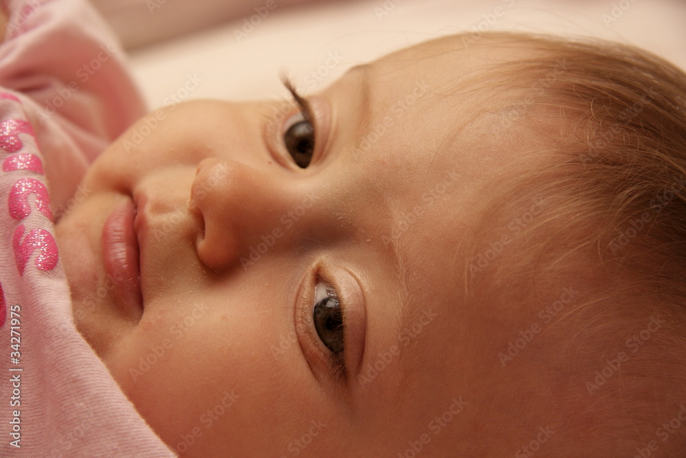 bambina coricata nel lettino sorride bambina coricata nel lettino sorride