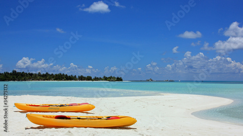 banc de sable blanc et canoës sur plage des îles maldives