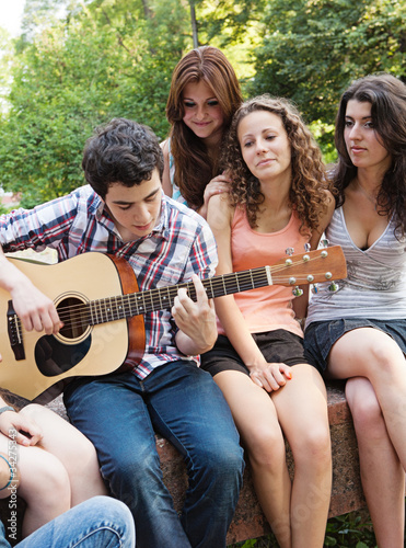 Cheerful teenagers playing guitar and singing © Andriy Petrenko