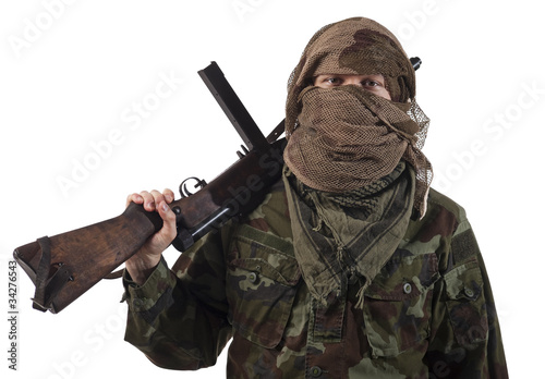 Camouflaged guerrilla soldier with hidden face and a machine gun photo