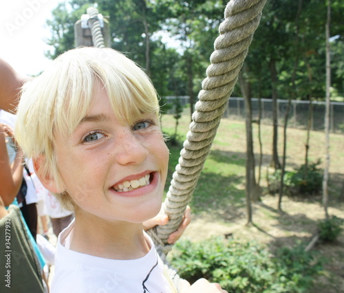 enfant blond sourire ,promenade sur pont suspendu photo