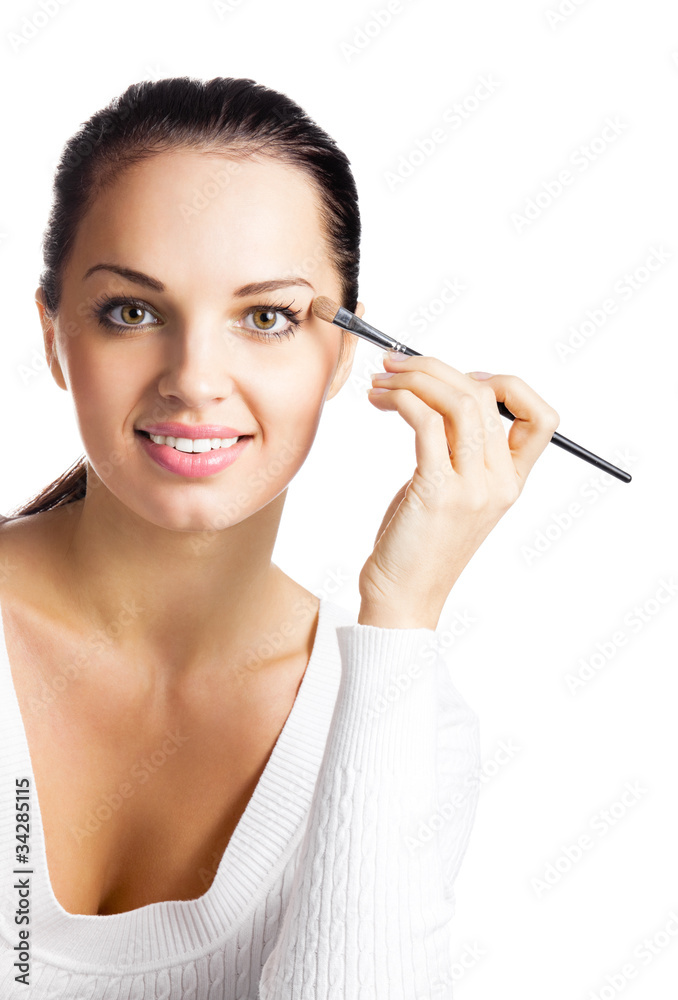 Young happy smiling woman applying eye shadow, isolated