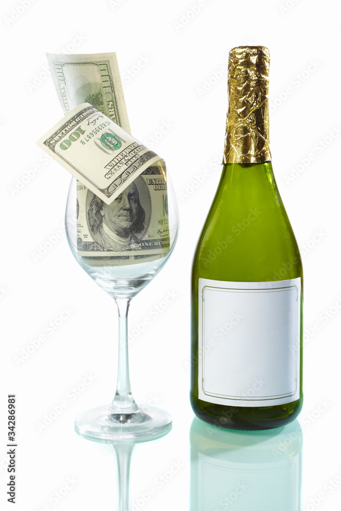 Glass filled of dollar bills and wine bottle Glass filled of dollar bills and wine bottle
