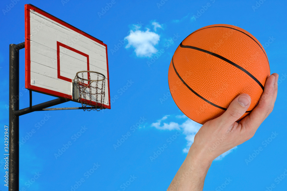 basketball hoop and human hand with ball.
