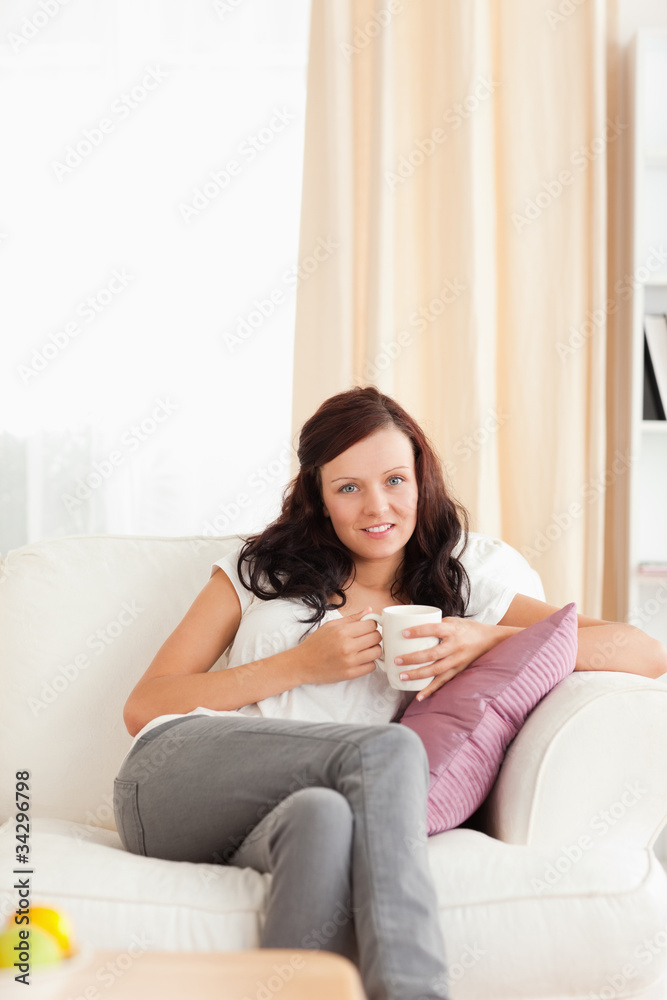 Woman holding a cup looking into the camera Woman holding a cup looking into the camera