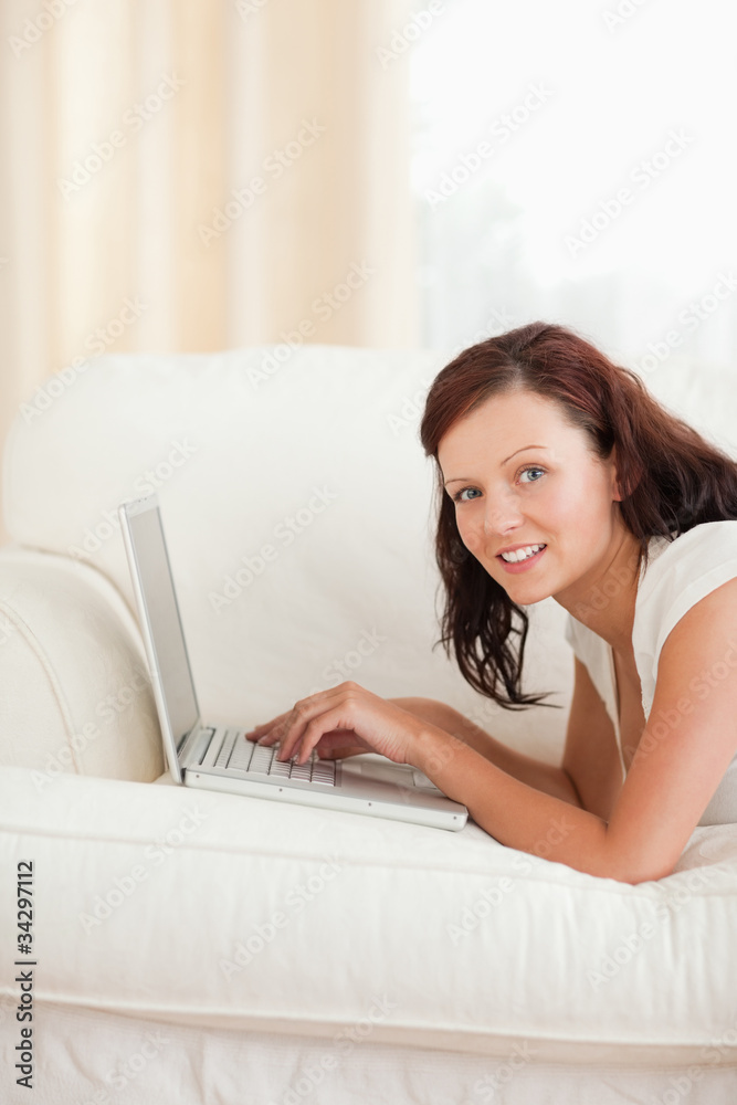Joyful woman working on a notebook looking into the camera Joyful woman working on a notebook looking into the camera