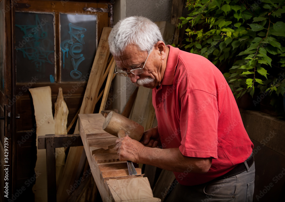 Old woodcarver working with mallet Old woodcarver working with mallet