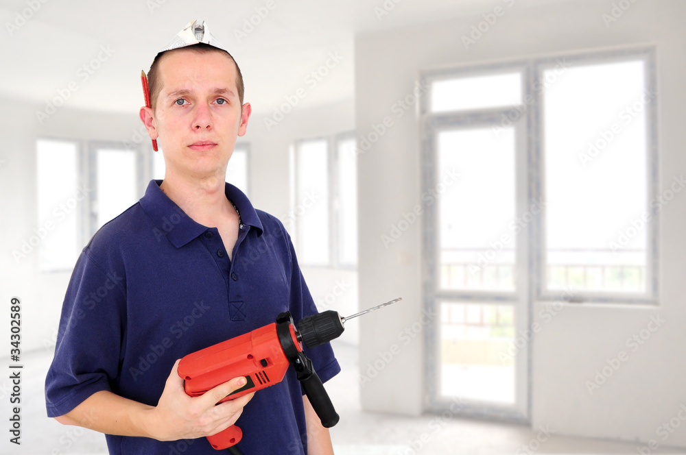 Young serious worker with drill Young serious worker with drill