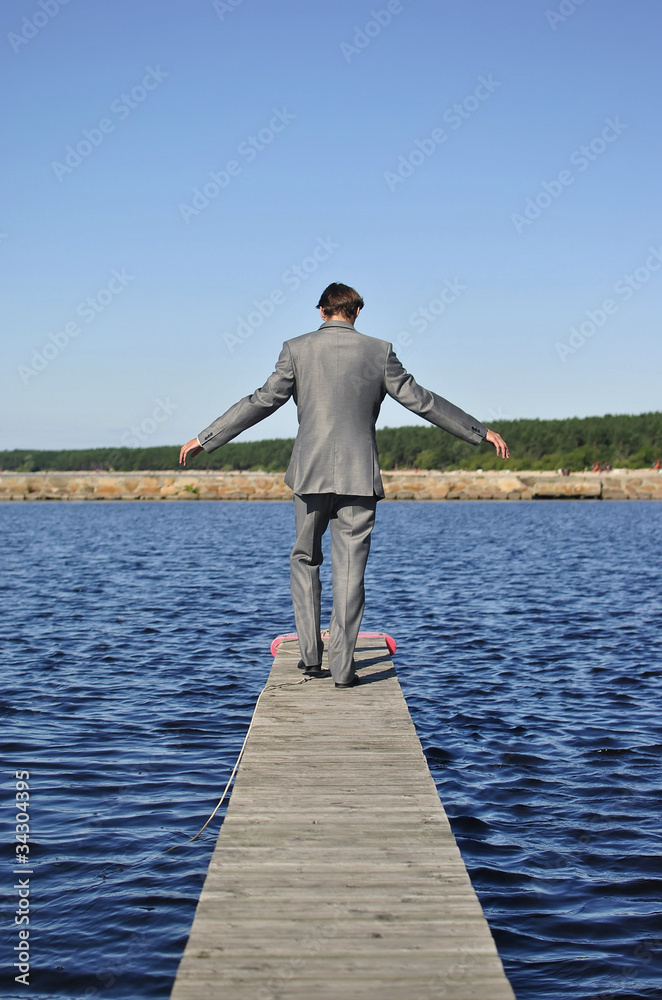 man in a gray suit walking on the pier