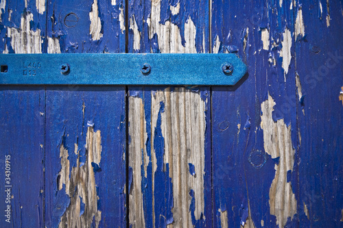 Old blue paint peeling from the window shutters in Betina photo