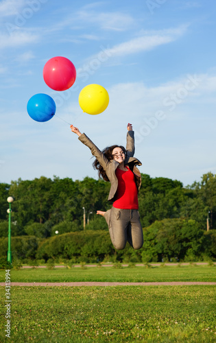 Business woman jumping with balloons