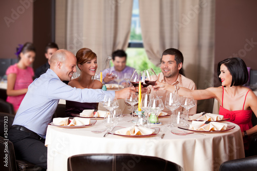 young people toasting restaurant table