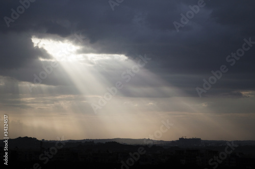 Sunlight breaking through a thick blanket of clouds © vinodpillai