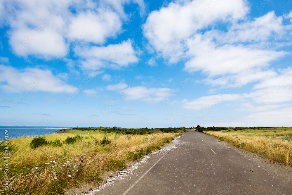 scenic, country road under cloudy blue sky