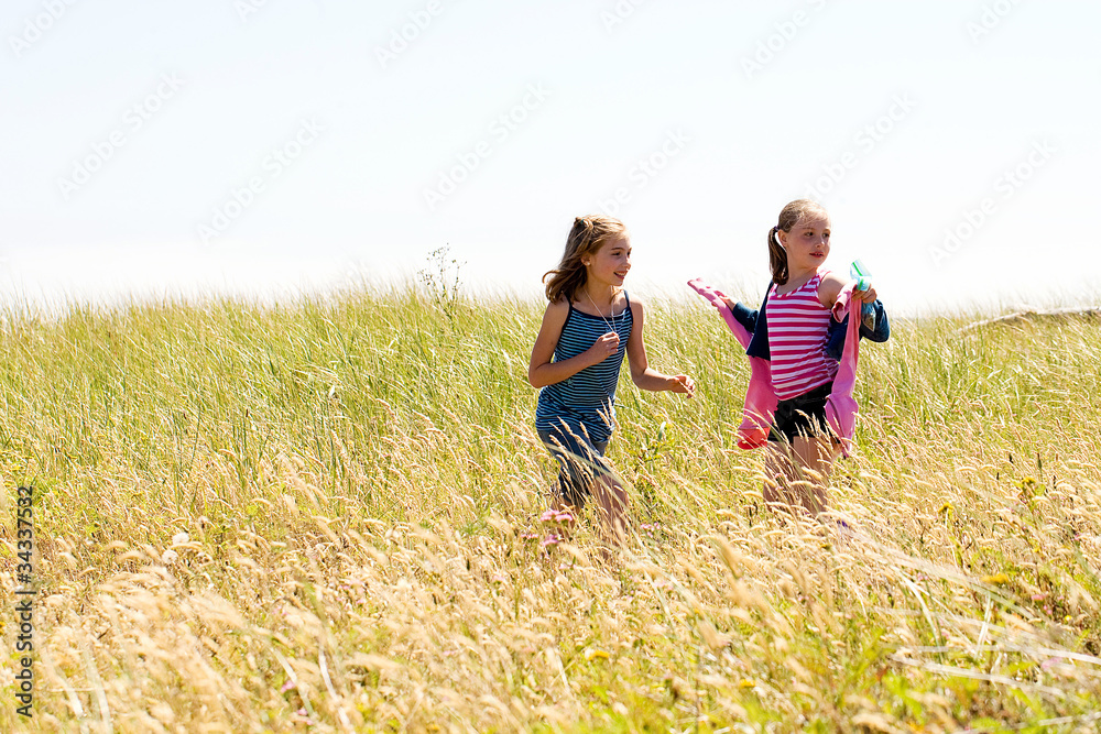 Children running in a grassy field.