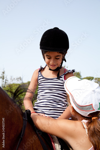 bambina che sale a cavallo photo