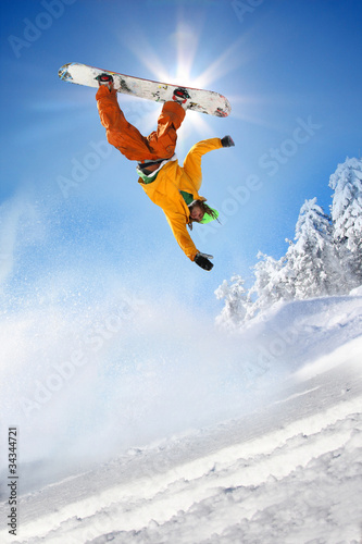 Snowboarder jumping against blue sky #34344721