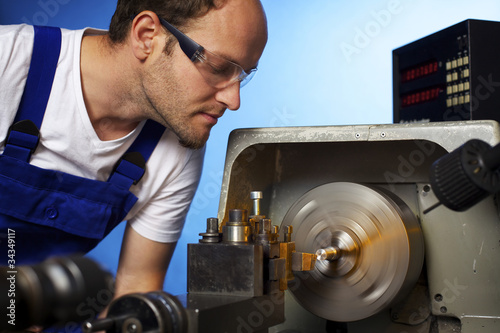 Close-up of technician working on lathe machine photo