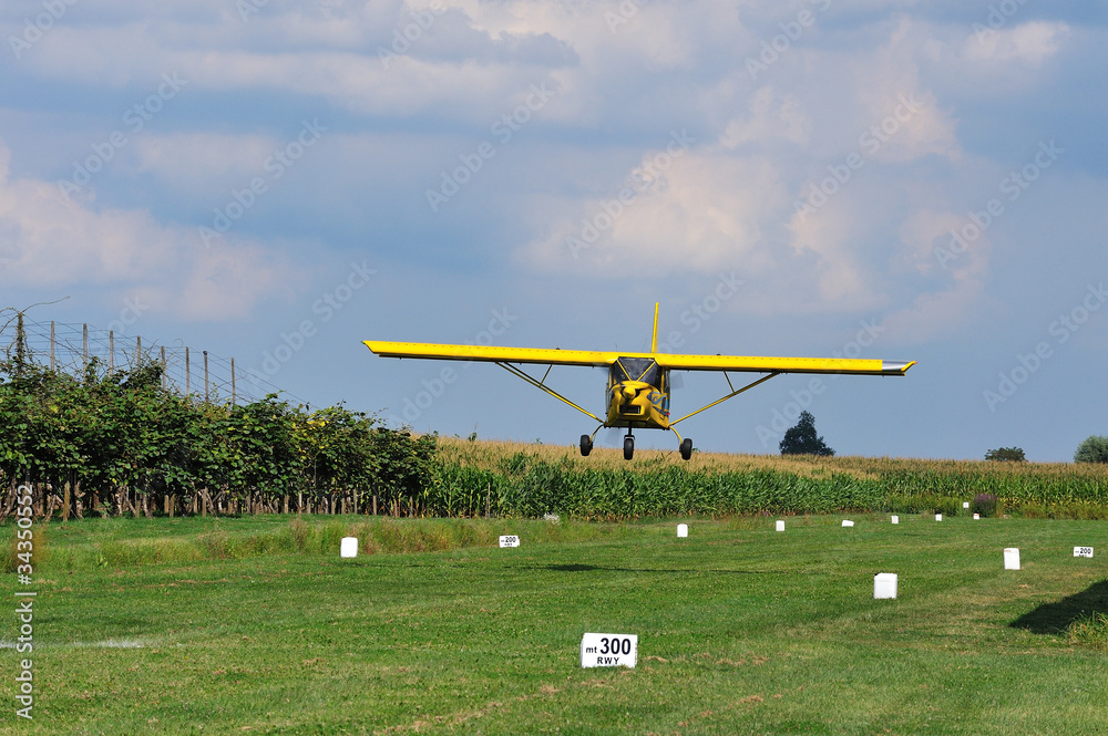 small plane landing on grass yellow small plane landing on grass yellow
