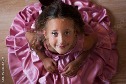 Smiling cute little girl in a pink dress festive