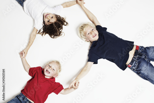 Smiling children on floor holding hands