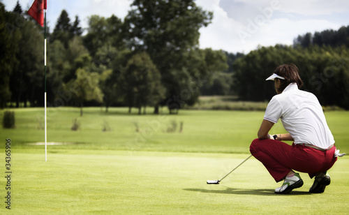 Woman examining green before putting.