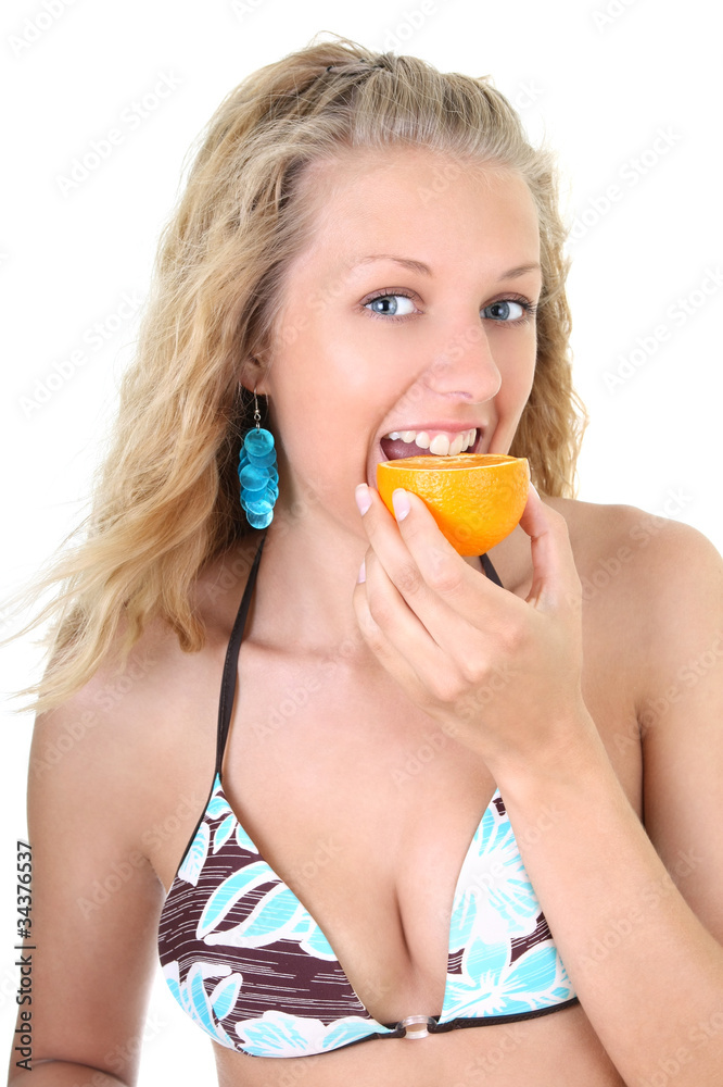 Happy blonde woman biting orange Happy blonde woman biting orange