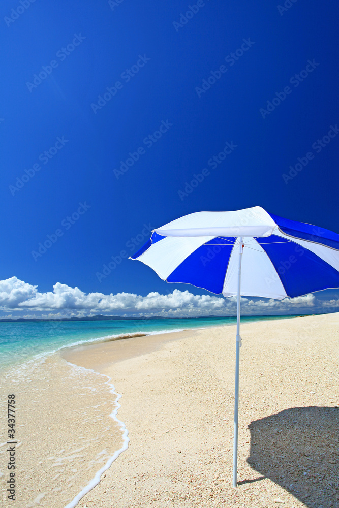 水納島の真っ白い砂浜に立つビーチパラソル