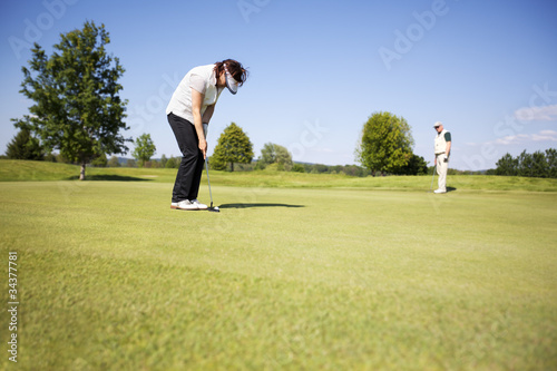 Two senior golf player on green.