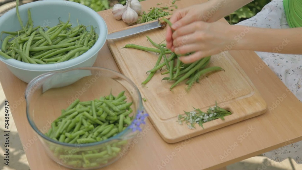 Preparing young green bunch of beans for slicing outdoors Preparing young green bunch of beans for slicing outdoors
