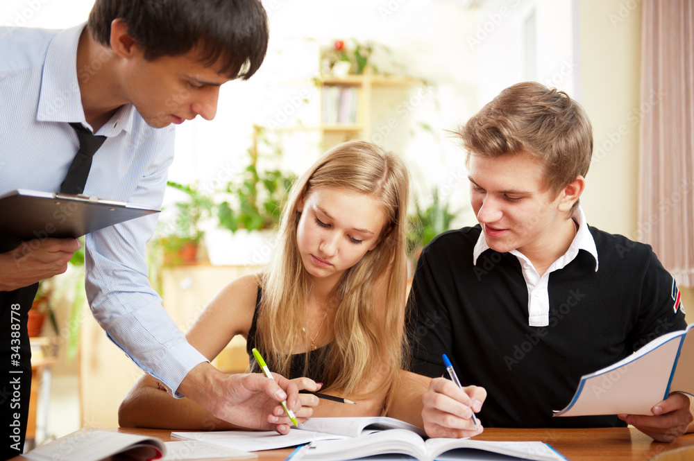 Teacher helping students in school classroom. Horizontally frame Teacher helping students in school classroom. Horizontally frame