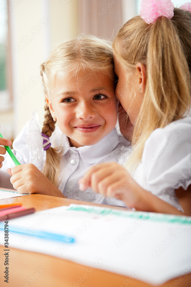 Two little girls gossip in classroom Two little girls gossip in classroom
