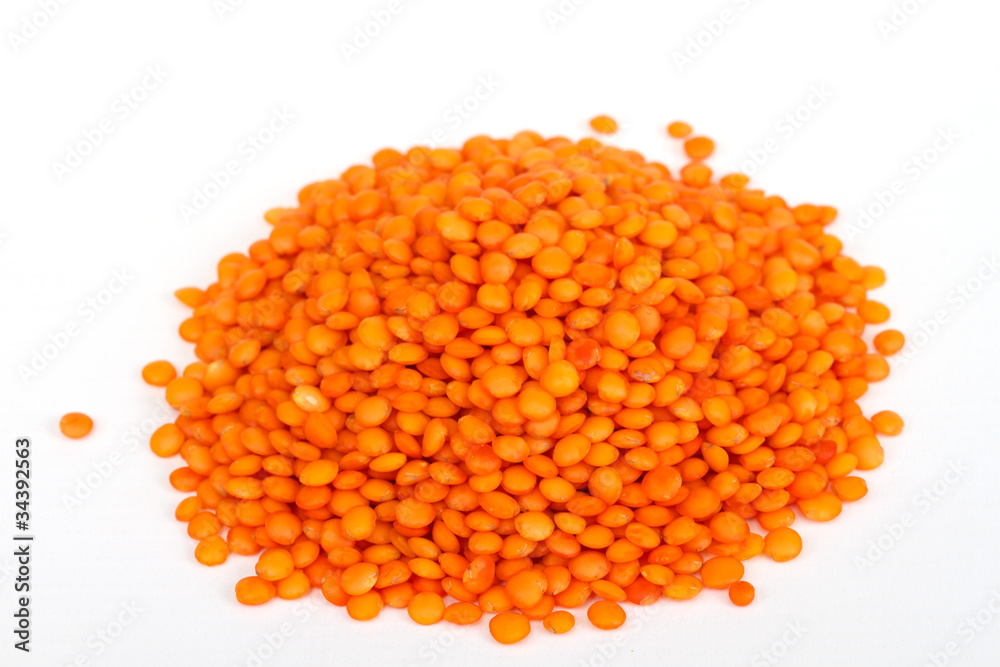 Heap of raw red lentils isolated on white background