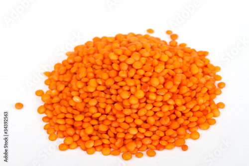 Heap of raw red lentils isolated on white background