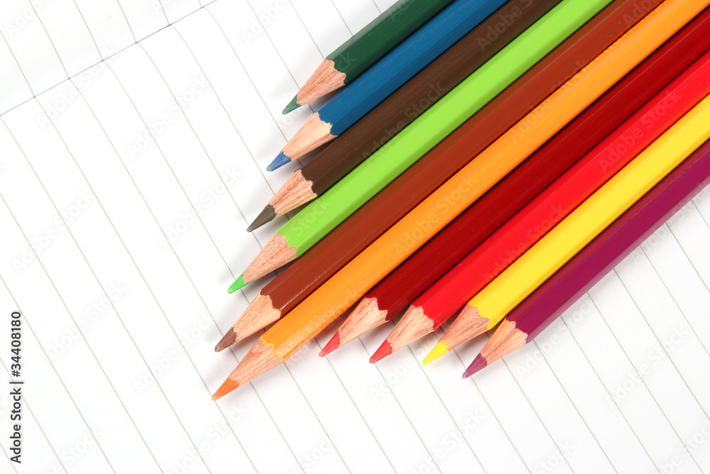 Pencil crayons on white writing paper Pencil crayons on white writing paper