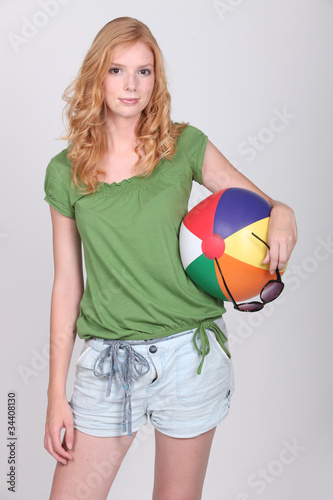 Young woman holding a beach ball