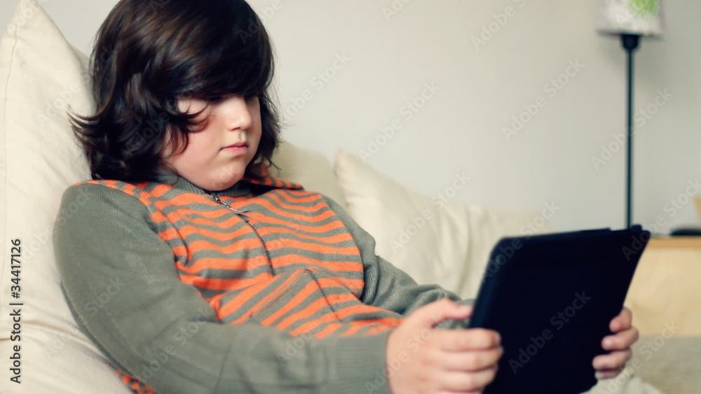 Young teenager playing game on tablet computer Young teenager playing game on tablet computer