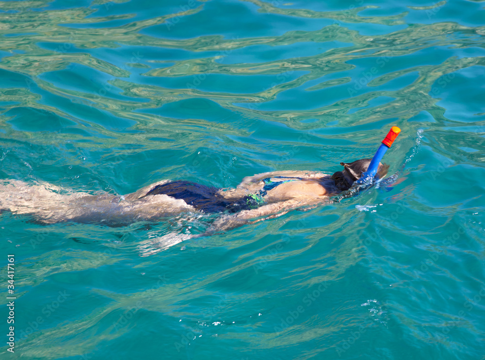 Young woman snorkeling in blue water