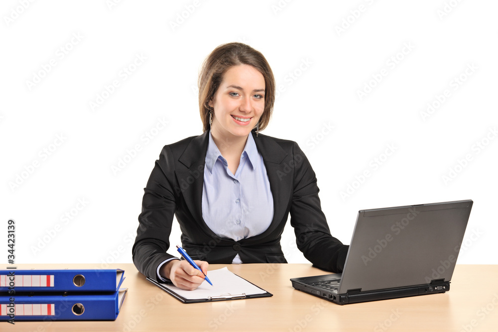 A smiling young businesswoman working on a laptop A smiling young businesswoman working on a laptop