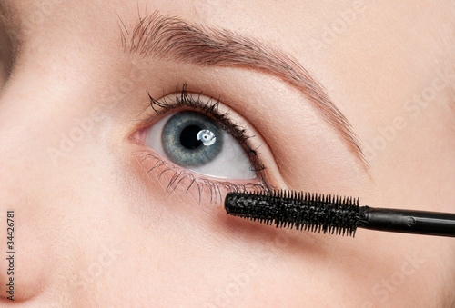 Beautiful woman applying mascara
