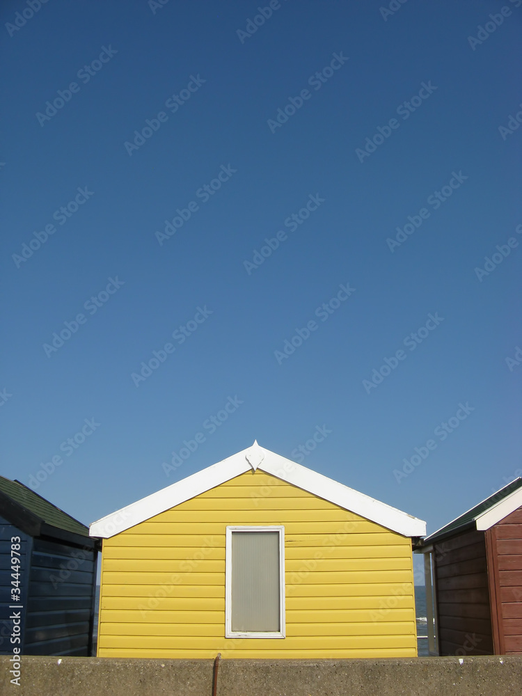 Bright yellow beach hut on an English beach Bright yellow beach hut on an English beach
