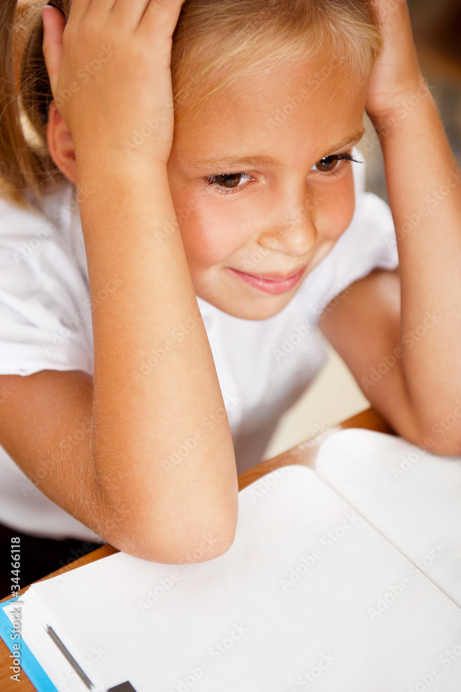 Image of smart child reading interesting book in classroom Image of smart child reading interesting book in classroom