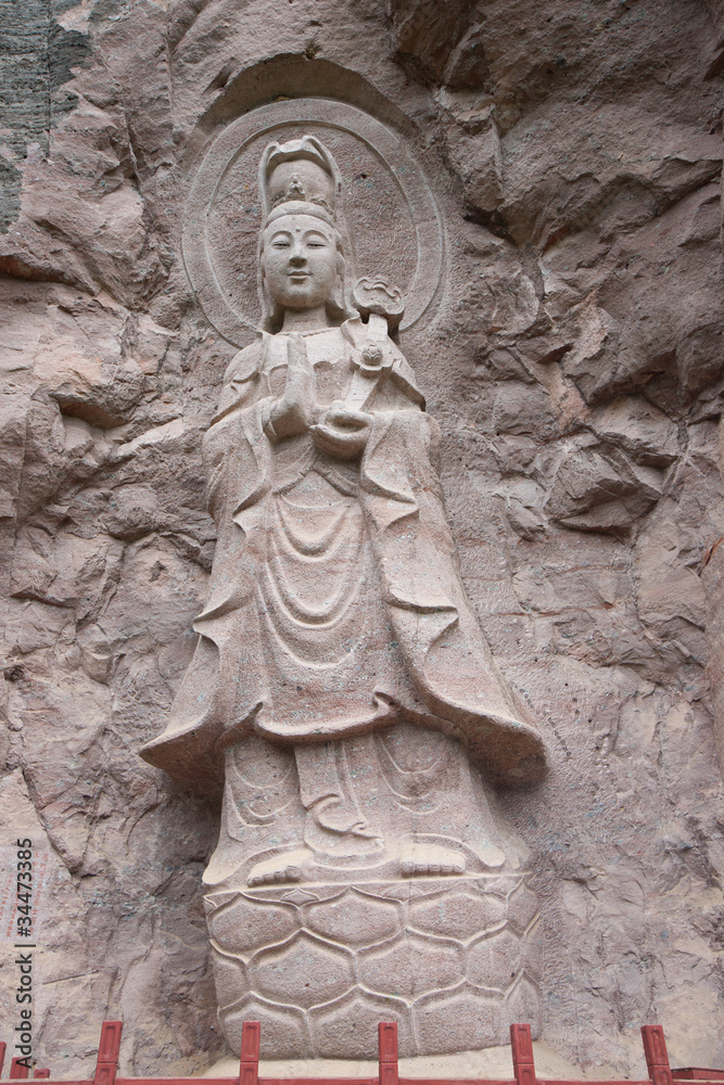 Obraz premium Buddha statue on the rock cliff