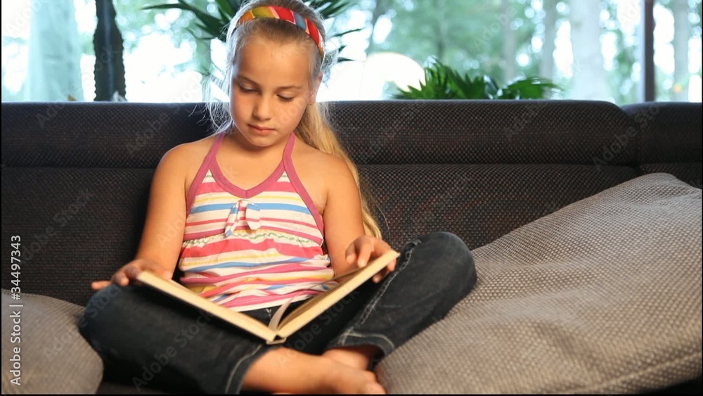 girl relaxing on the sofa and reading a book
