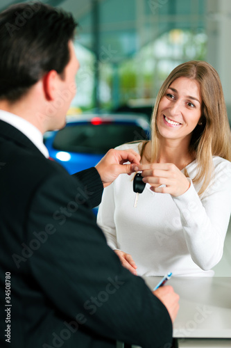 Woman buying car - key being given