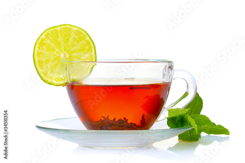 black tea in cup, mint and lime isolated on white